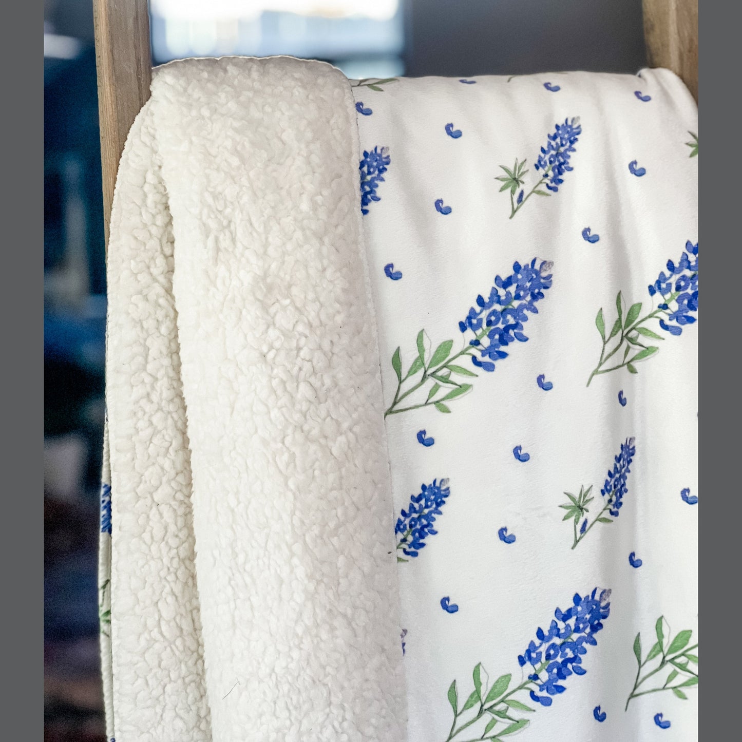 Bluebonnet-patterned plush throw blanket in shades of blue and green, measuring 60x80 inches, on a white background.