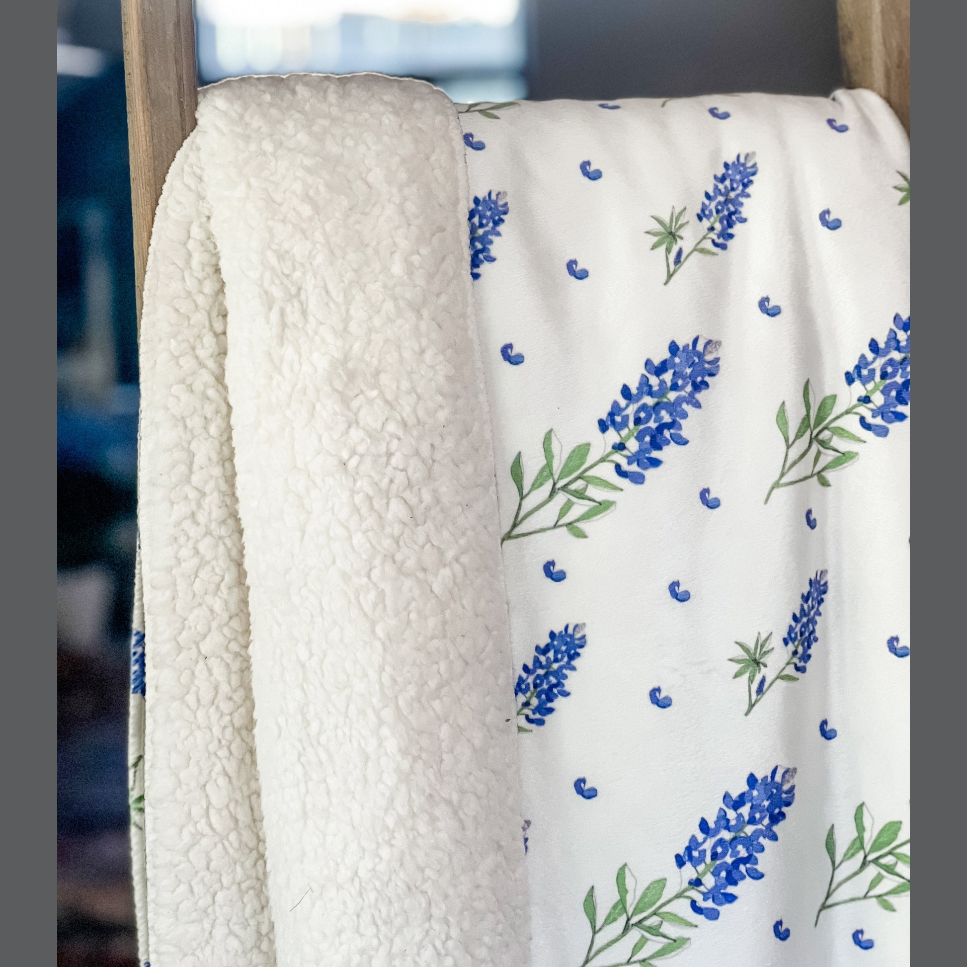 Bluebonnet-patterned plush throw blanket in shades of blue and green, measuring 60x80 inches, on a white background.