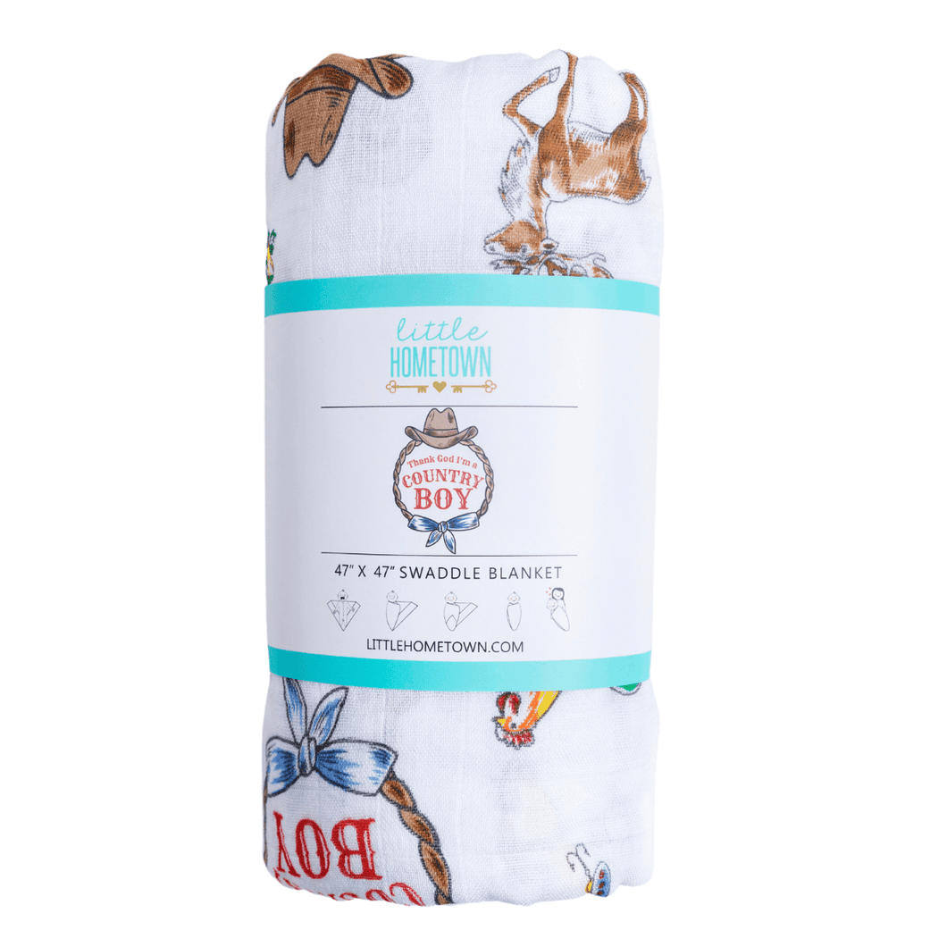 Country Boy muslin swaddle blanket with a playful farm animal print, featuring cows, pigs, and tractors.