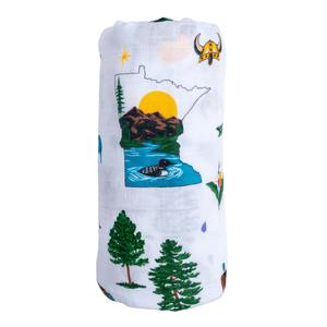 White muslin swaddle blanket with "Minnesota Baby" text and state outline, featuring a heart over Minneapolis.