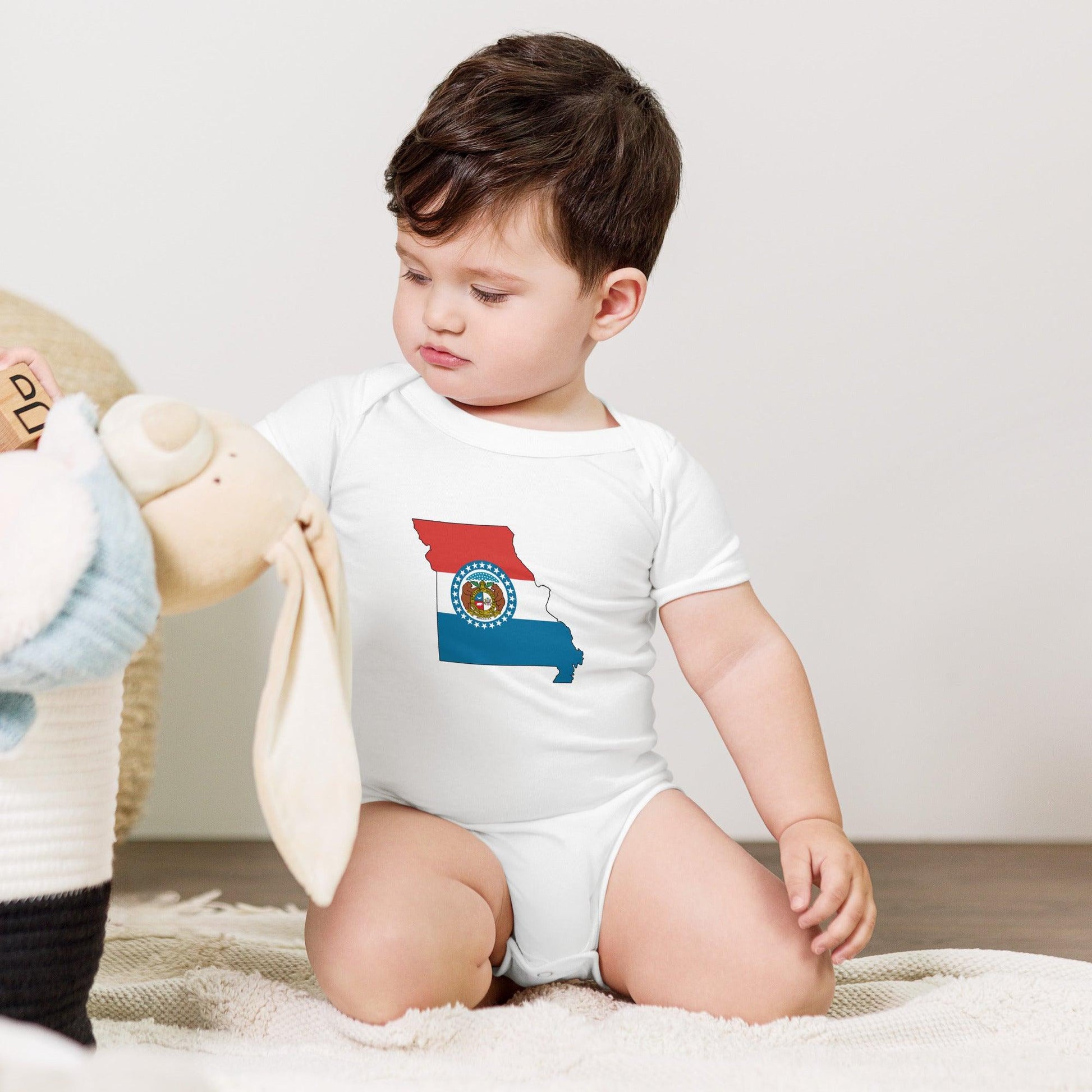 Baby onesie with the Missouri state flag design, featuring a blue, red, and white color scheme with the state seal.