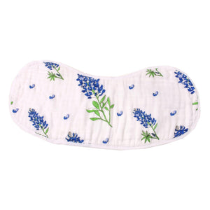 Baby bib and burp cloth set with bluebonnet floral pattern on white fabric, displayed on a wooden surface.