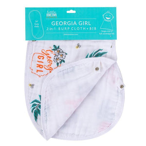 Pink baby bib and burp cloth set with "Georgia Girl" text, featuring a peach and floral design on a white background.