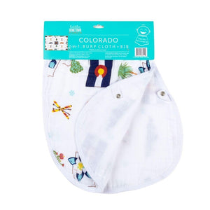 Baby wearing a white bib with colorful Colorado-themed illustrations, including mountains, trees, and animals.