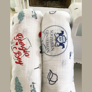 Baby swaddled in a white muslin blanket with "Georgia Boy" text, featuring blue and red state-themed illustrations.