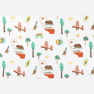 California Baby muslin swaddle blanket and burp cloth set with playful bear and tree patterns on a white background.