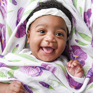 Gift set with baby muslin swaddle blanket and burp cloth, featuring a delicate irises floral pattern.