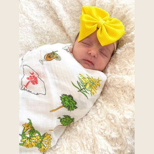 Pink muslin swaddle blanket and burp cloth set with "South Carolina Girl" text, featuring state icons and flowers.