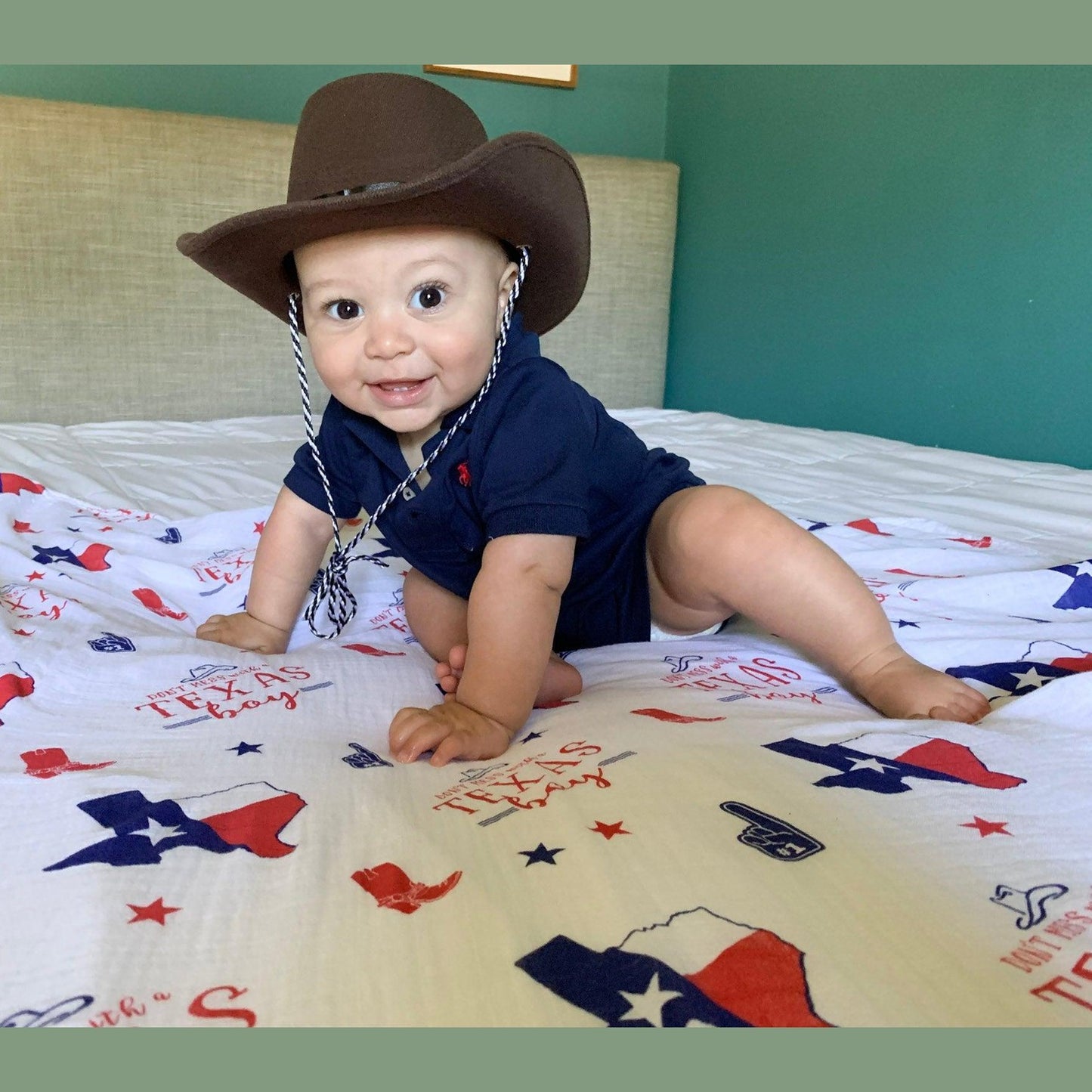 Texas-themed baby gift set with muslin swaddle blanket, burp cloth, and bib featuring state icons and blue accents.