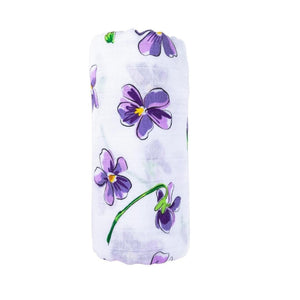 Gift set with violet baby muslin swaddle blanket and burp cloth/bib combo, neatly folded and displayed.