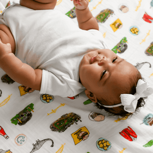 Pittsburgh-themed baby gift set with a muslin swaddle blanket and burp cloth, featuring city landmarks and icons.