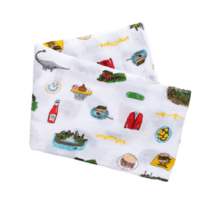 Pittsburgh-themed baby gift set with a muslin swaddle blanket and burp cloth, featuring city landmarks and icons.
