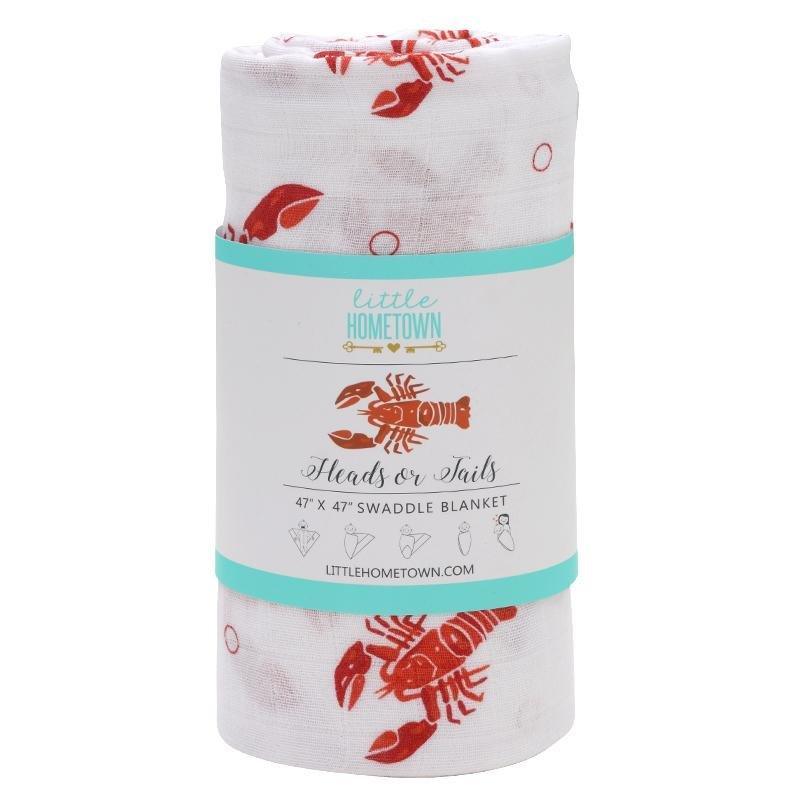 White muslin baby swaddle blanket with playful blue and green fish pattern, folded neatly on a white background.