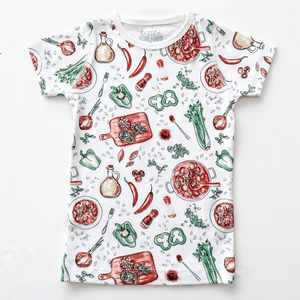 Toddler wearing colorful Jambalaya-themed pajamas with shrimp, sausage, and rice illustrations on a white background.