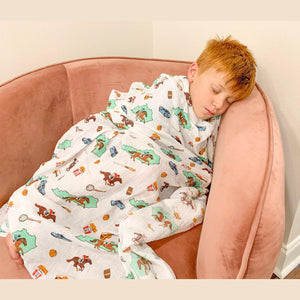 Soft muslin baby swaddle blanket with Kentucky state icons, including horses, bourbon, and bluegrass motifs.