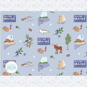 Colorful plush throw blanket featuring a map of Maine, Welcome to Maine sign, moose, blueberries, and other landmarks, animals, and vibrant illustrations.