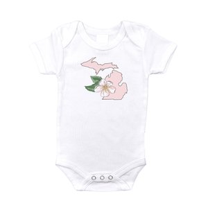 White baby onesie with "Michigan Apple Blossom" text and a pink apple blossom graphic on the front.
