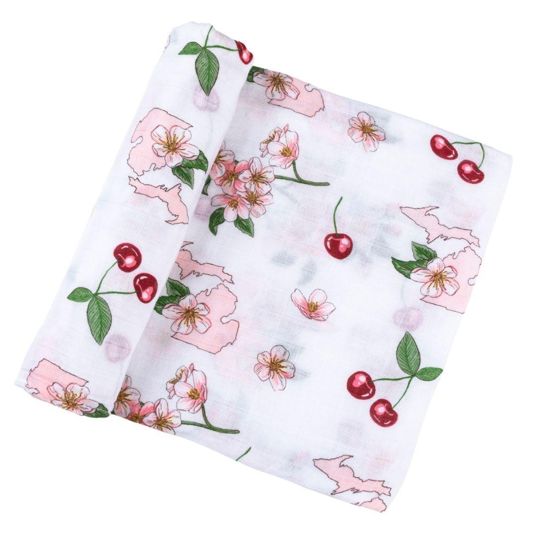 White muslin swaddle blanket with colorful floral patterns and "Michigan Baby" text, laid flat on a white background.