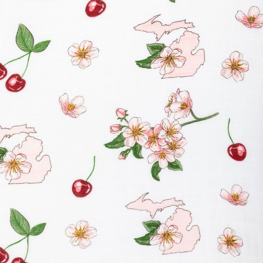 White muslin swaddle blanket with colorful floral patterns and "Michigan Baby" text, laid flat on a white background.