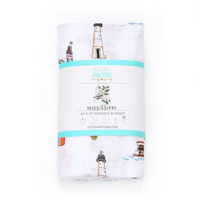 White muslin swaddle blanket with a colorful map of Mississippi, featuring landmarks and playful illustrations.
