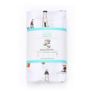 White muslin swaddle blanket with a colorful map of Mississippi, featuring landmarks and playful illustrations.