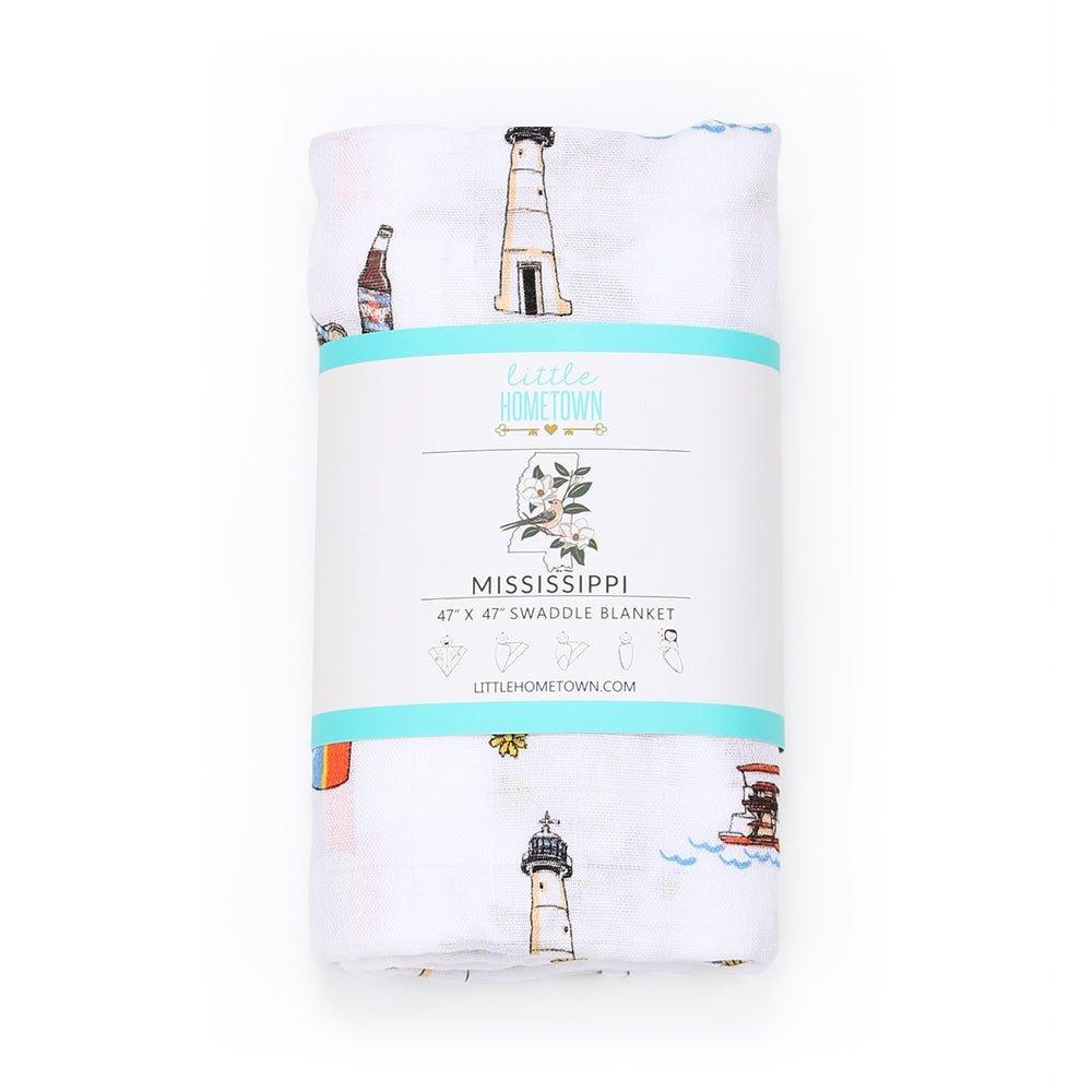 White muslin swaddle blanket with a colorful map of Mississippi, featuring landmarks and playful illustrations.