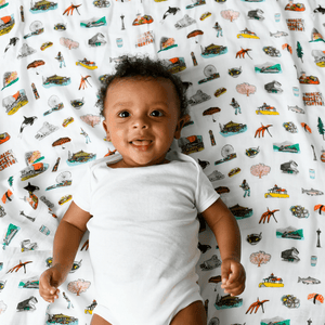 Seattle-themed baby muslin swaddle blanket with iconic landmarks in soft pastel colors, including the Space Needle.