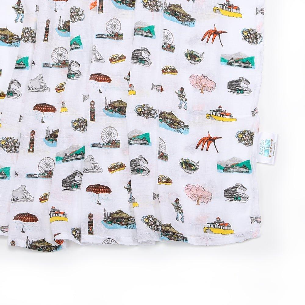 Seattle-themed baby muslin swaddle blanket with iconic landmarks in soft pastel colors on a white background.