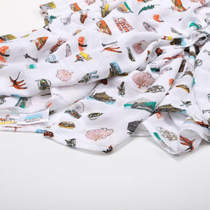 White muslin swaddle blanket with Seattle landmarks like the Space Needle and Pike Place Market, in soft pastel colors.