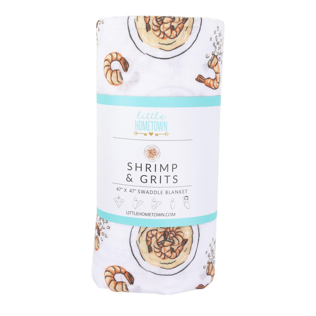 White muslin swaddle blanket with playful shrimp and grits illustrations, featuring vibrant orange and yellow hues.