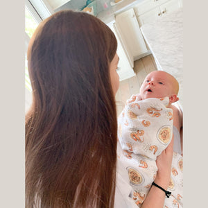 White muslin swaddle blanket with colorful shrimp and grits pattern, featuring bowls, shrimp, and corn.