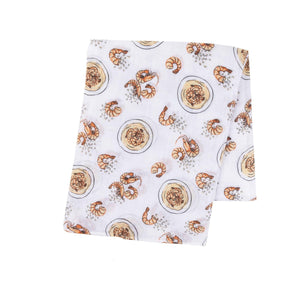 Soft muslin baby swaddle blanket with playful shrimp and grits pattern, featuring pastel colors and whimsical design.