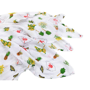Baby girl swaddled in a white muslin blanket with pink South Carolina motifs, lying on a soft surface.