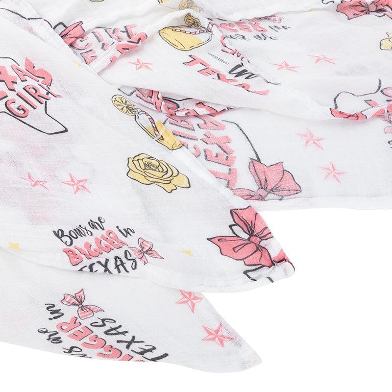 Texas-themed baby girl muslin swaddle blanket with pink accents, featuring state icons and "Texas Baby Girl" text.