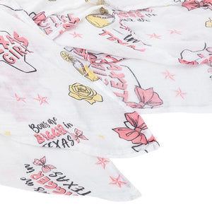 Texas-themed baby girl muslin swaddle blanket with pink accents, featuring state icons and "Texas Baby Girl" text.