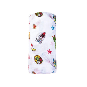 White muslin swaddle blanket with colorful Texas-themed illustrations, including cacti, cowboy boots, and armadillos.
